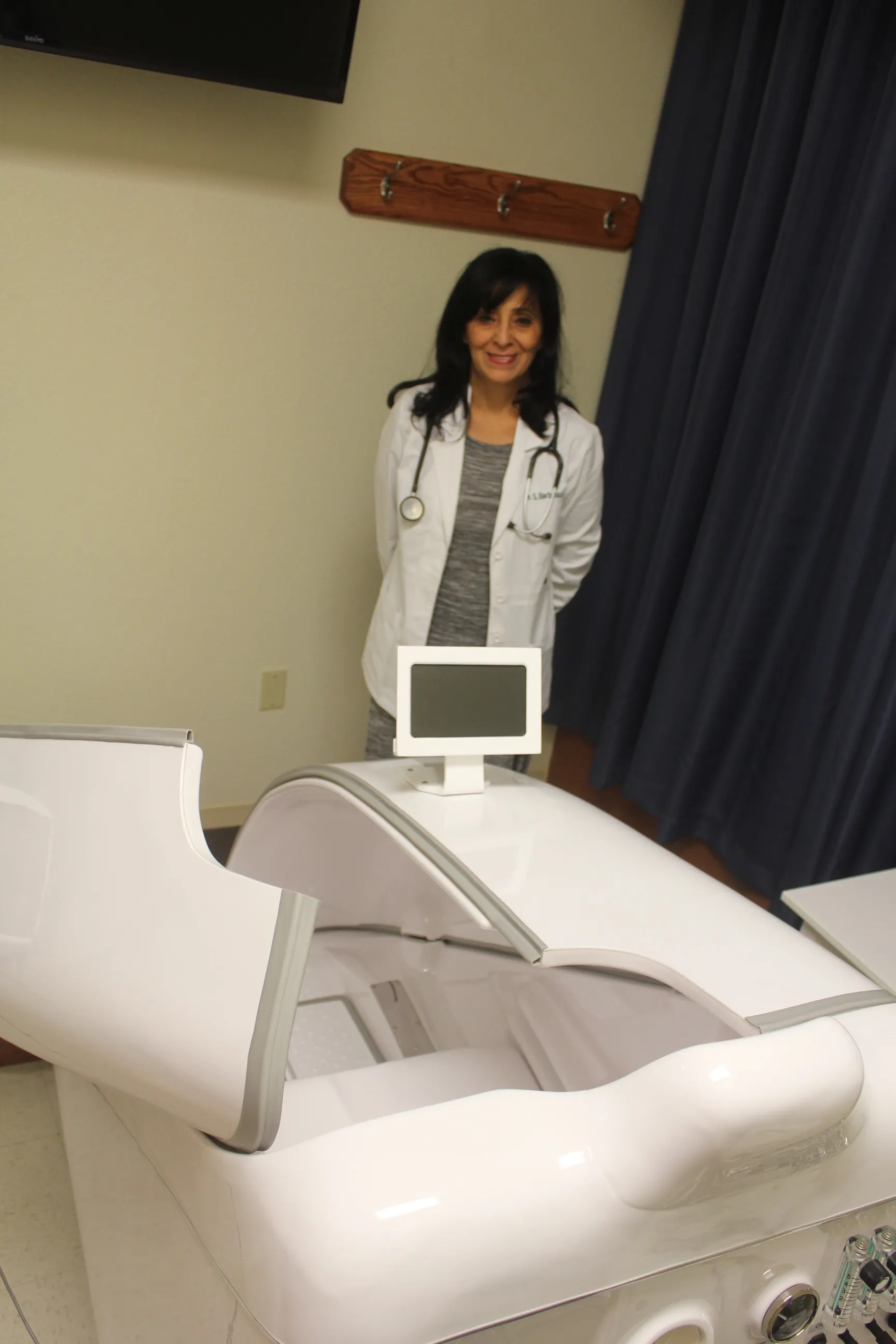 Dra. Shirley Barbosa en la sala de consulta de bienestar con equipo de sauna de ozono